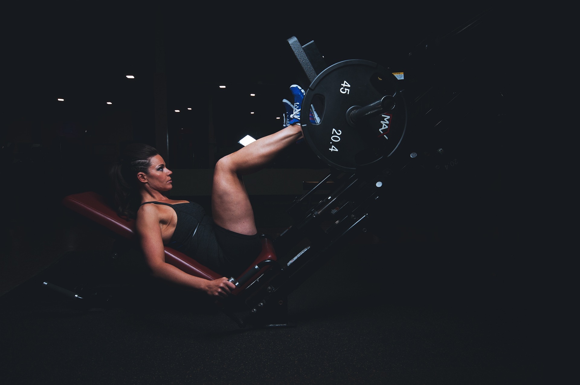 An athetic woman working out with a heavy fitness equipment for legs